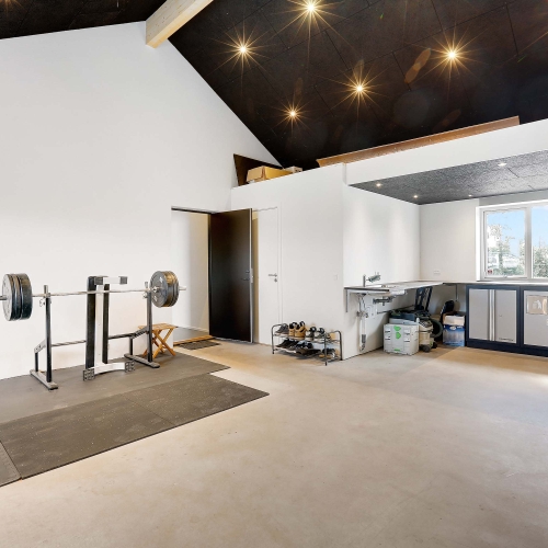 Garage med fitnessområde og håndlavet arbejdsstation fra tømrer.
