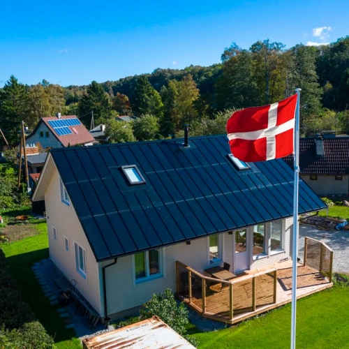 Hus med ståltag med integreret solceller