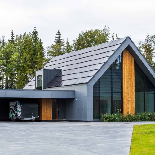 Moderne hus med fulddækkende solceller i tagpaneler