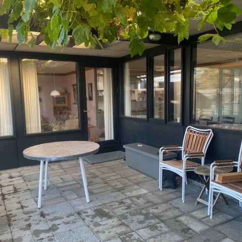 Tømrerarbejde med sort facade, vinduer og en overdækket terrasse i Lyngby