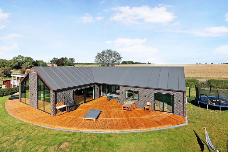 Moderne hus med en rummelig buet træterrasse i naturskønne omgivelser i Hellerup.