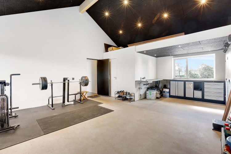 Garage med fitnessområde og håndlavet arbejdsstation fra tømrer.